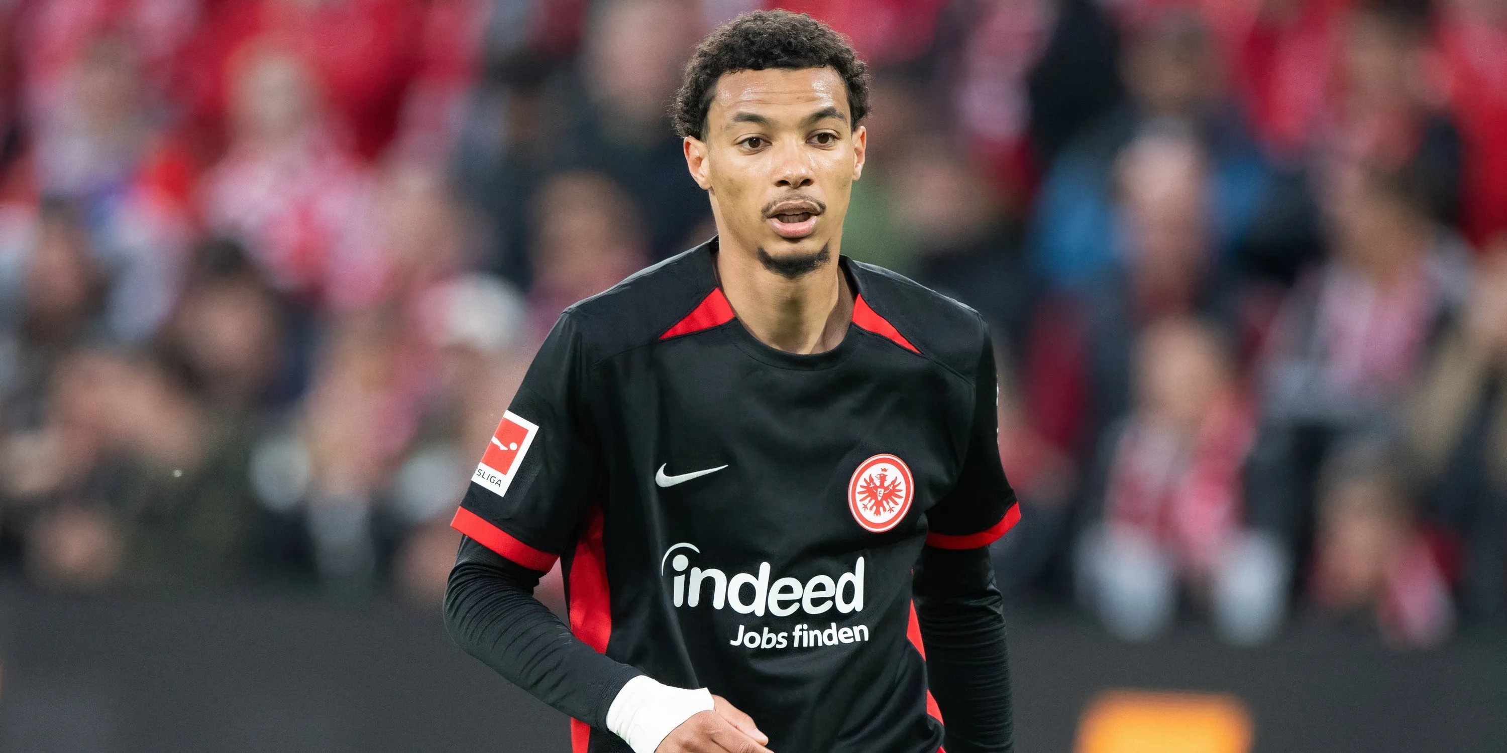 Tiền đạo Hugo Ekitike trong màu áo Eintracht Frankfurt tranh chấp bóng, minh họa khả năng tham gia toàn diện vào lối chơi và sự dẻo dai trên sân.